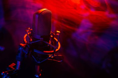 Siyah arka planda kırmızı mavi dumanlı profesyonel mikrofon..