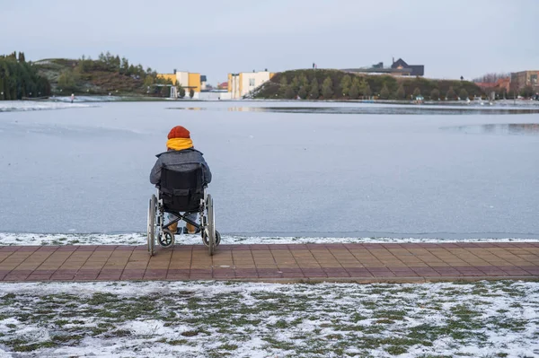 Λευκή γυναίκα σε αναπηρικό καροτσάκι περπατά στη λίμνη το χειμώνα.. — Φωτογραφία Αρχείου