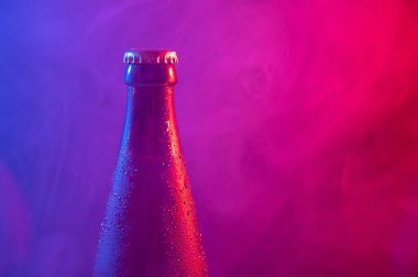 Mavi pembe sisli cam bira şişesi.