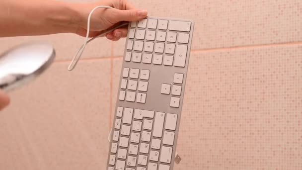 Detailní záběr žena myje bílý počítač klávesnice pod tekoucí vodou. — Stock video