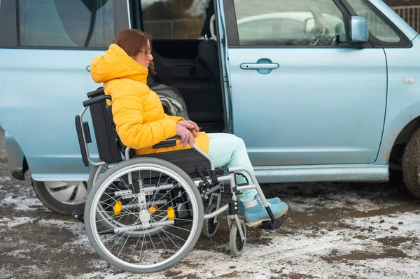 Caucasian woman in a wheelchair gets into the car. — 图库照片