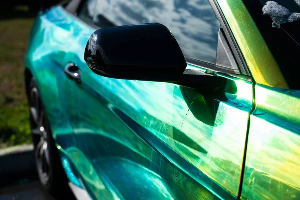 車は緑がかった黄色の色合いのカメレオン塗料で塗装されています. — ストック写真