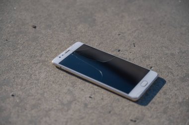 Kaldırımda kırık ekranlı bir telefon.. 