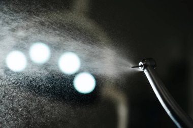 Diş türbini su püskürtücüsüyle kapatın. Dişçi ekipmanları.