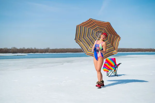 Caucasian woman in a swimsuit sunbathes on the snow in winter. — Fotografia de Stock