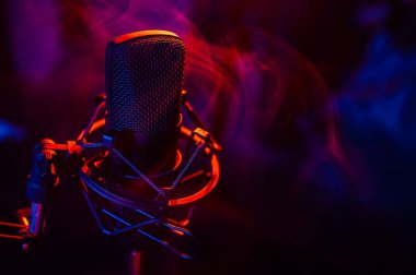 Siyah arka planda kırmızı mavi dumanlı profesyonel mikrofon..