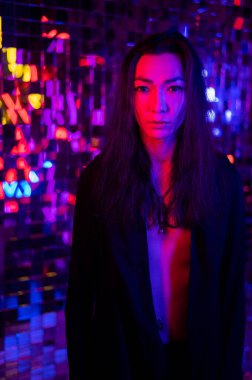 Bir androjenik modelin yakın plan portresi. Stüdyoda neon ışıklı bir erkek transseksüel..