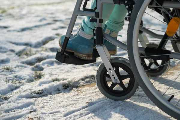 Close-up van benen van vrouw in rolstoel in de winter buiten. — Stockfoto