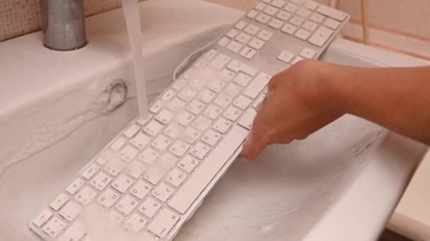 Vrouw wassen witte computer toetsenbord met een spons met schuim. — Stockvideo