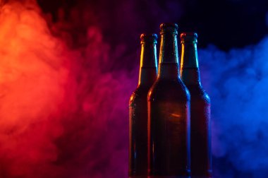 Mavi-pembe bir siste üç şişe bira..