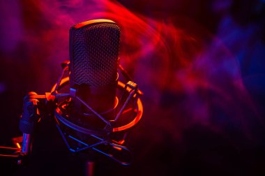 Siyah arka planda kırmızı mavi dumanlı profesyonel mikrofon..