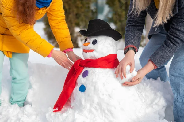 Two faceless Caucasian women are making a snowman. Winter fun. — Stock Photo, Image