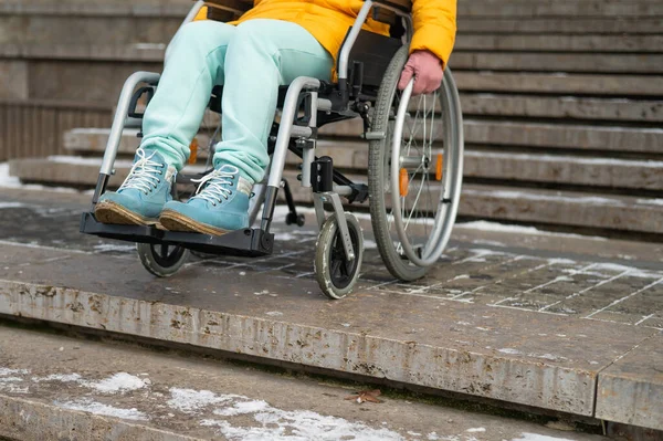 Женщина в инвалидном кресле рядом с лестницей в парке зимой. — стоковое фото