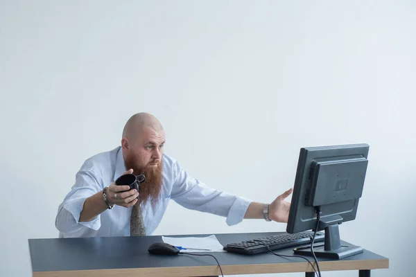 Problemas para el oficinista. Un hombre calvo con una camisa blanca se sienta en un escritorio con una computadora y está estresado por el fracaso. Una crisis nerviosa . —  Fotos de Stock