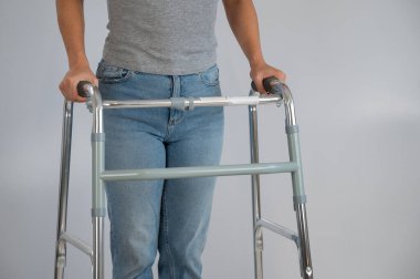 Beyaz bir arka planda yürüyen bir kadın var.