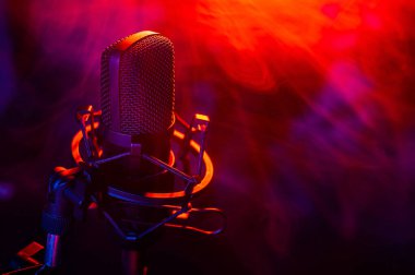 Siyah arka planda kırmızı mavi dumanlı profesyonel mikrofon..