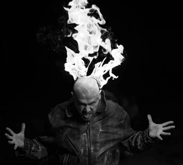 어두운 배경에 불타는 머리를 한 가죽 자켓을 입고 있는 대머리 남자. — 스톡 사진