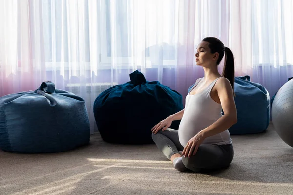 Güzel genç hamile kadın pilates yapıyor. Hamile anne bir çocuğun doğmasını beklerken spor yapar.. — Stok fotoğraf