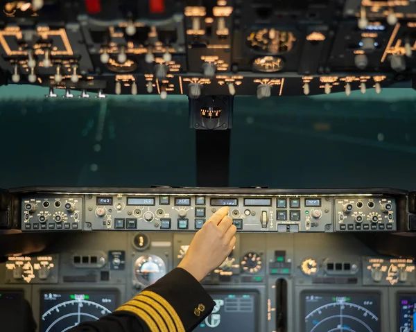 Close-up of a pilots hand on an airplane control panel. — Stock Photo, Image