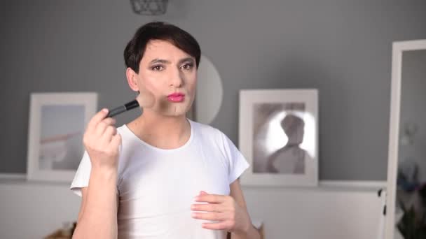 Ένας ομοφυλόφιλος βάζει μακιγιάζ μπροστά από έναν καθρέφτη. Αρσενικό τρανς. — Αρχείο Βίντεο