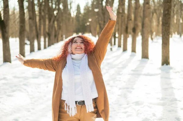 Товста жінка слухає музику з навушниками і танцями в парку взимку . — стокове фото