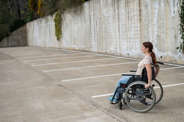 Γυναίκα σε αναπηρικό καροτσάκι σε πάρκινγκ.. — Φωτογραφία Αρχείου