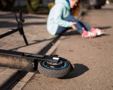 Beyaz bir kadın elektrikli scooterdan düştü ve bacağını yaraladı. Acı çekiyor..