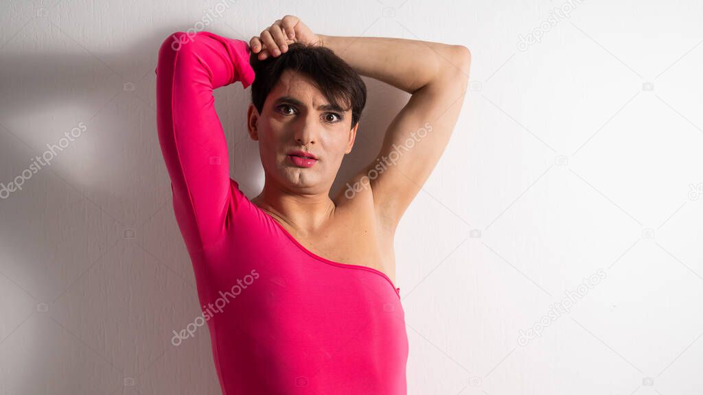 Homosexual in a pink female dress. A man in make-up.