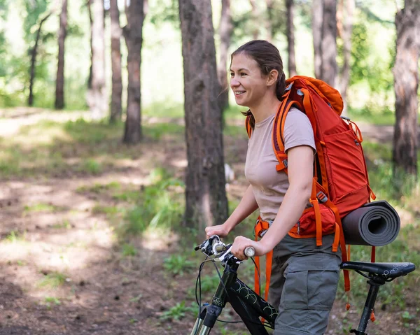 Mujer caucásica monta una bicicleta en el bosque — Foto de Stock