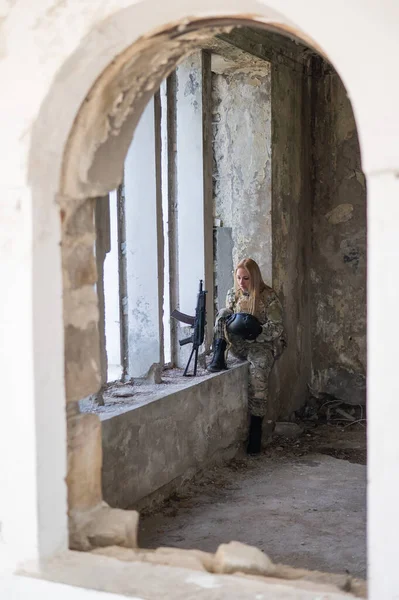 Biała wojskowa kobieta w zniszczonym budynku. — Zdjęcie stockowe