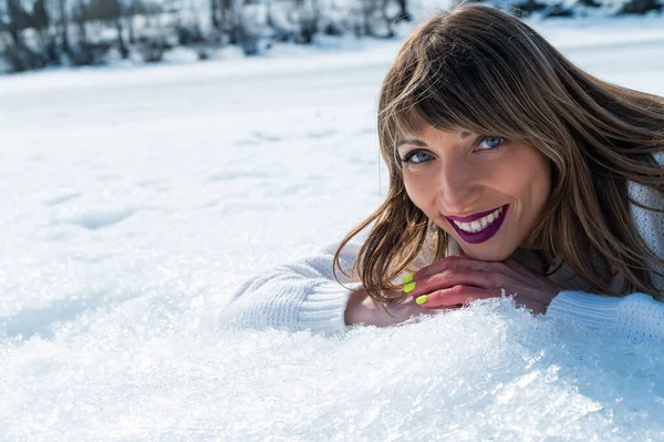 Gros plan portrait d'une femme caucasienne allongée sur la neige. — Photo