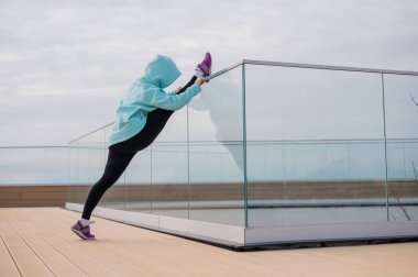 Tişörtlü beyaz bir kadın sicimin üzerinde esniyor.. 