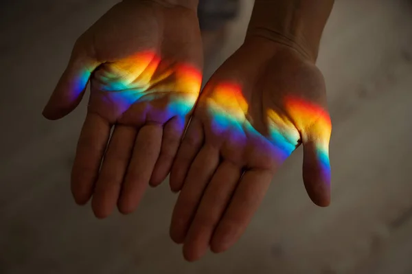 Rainbow ray on a womans hand. — Stock Photo, Image