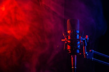 Siyah arka planda pembe dumanlı profesyonel mikrofon..
