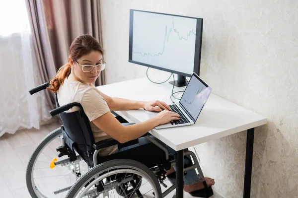 Mulher branca em cadeira de rodas trabalhando no laptop. — Fotografia de Stock
