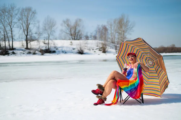 Caucasian woman in a swimsuit sunbathes on the snow in winter. — Fotografia de Stock