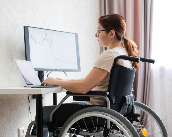 Biała kobieta na wózku inwalidzkim pracująca na laptopie. — Zdjęcie stockowe