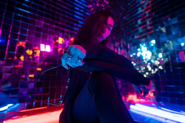 Asyalı adam güneş gözlüğü tutuyor. Neon fotoğraf stüdyosu. 