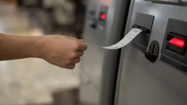 Een vrouw neemt een cheque aan van een geldautomaat.. — Stockfoto