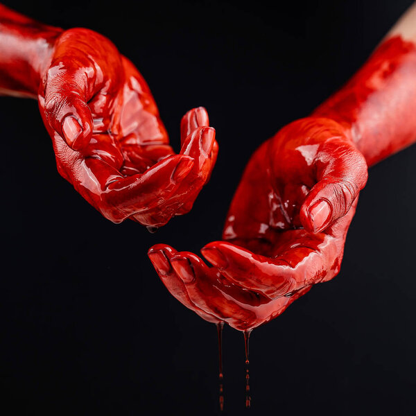 Womens hands in blood on a black background.