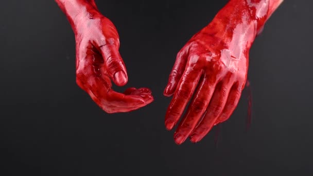 Kvinnors händer i blod på en svart bakgrund. — Stockvideo