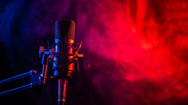 Siyah arka planda pembe dumanlı profesyonel mikrofon..