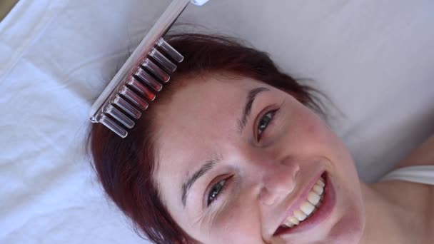 Běloška na proceduře péče o vlasy pomocí Darsonvalova aparátu. — Stock video