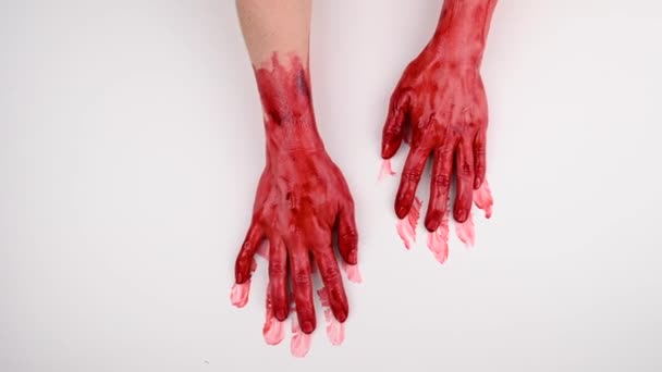 Bloody female hands slide over white background. — Stock Video