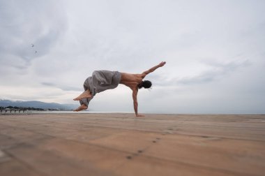 Çakıl taşlı plajda ters takla atan beyaz bir adam.. 