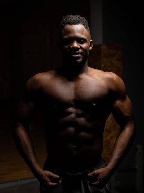 Karanlık bir stüdyoda çıplak gövdesi olan Afro-Amerikan bir adamın portresi. Kaslı adam..