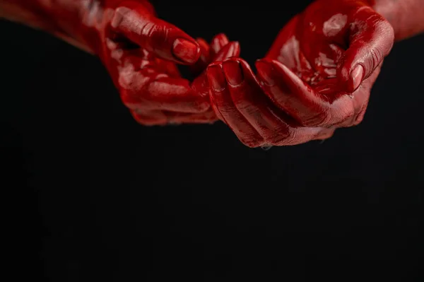 Kobiece dłonie we krwi na czarnym tle. — Zdjęcie stockowe