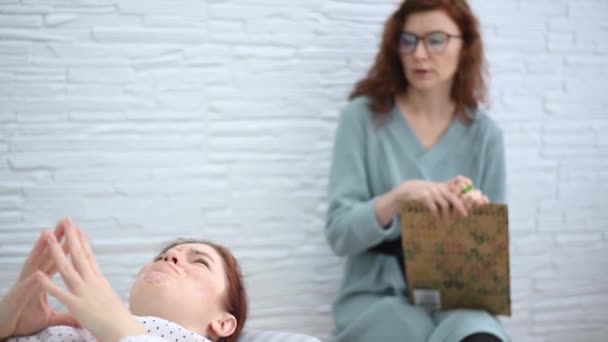 Una donna caucasica si sdraia su un divano ed esprime i suoi sentimenti, mentre uno psicologo prende appunti su un tablet.. — Video Stock