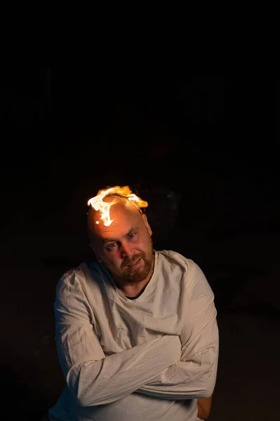 Uomo calvo in camicia di forza con una testa che brucia su uno sfondo scuro. — Foto Stock