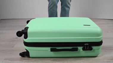 Kadın bavulun üstüne atlıyor..